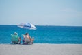 2 people in beach chairs on the sand on a beach in Florida