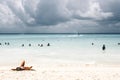 People on the beach enjoying the beautiful view of crazy clouds and the warmth of sun Royalty Free Stock Photo