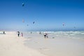 People enjoying wide white beach in Kalk Bay, South Africa. Kiteboarders on waves of Atlantic Ocean Royalty Free Stock Photo