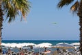 People on beach and landing plane.