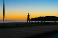 People on beach at Mount Maunganui at surise in silhouette doing morning fitnes exercise and walking by