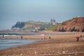 People on the beach at Whitby with the abbey on the cliffs in the background