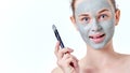 People, beauty, spa, cosmetology and skincare concept. Young teenage girl applying facial mask using brush.