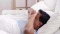 Indian man awaking and stretching in bed at home