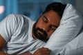 indian man sleeping in bed at home at night