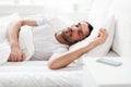 Man sleeping in bed with smartphone on nightstand Royalty Free Stock Photo