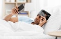 Sleepy indian man with smartphone lying in bed