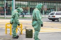 People in bio viral hazard protective suits. Disinfection and decontamination on a public place as a prevention against