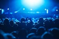 People, blue and crowd for concert, performance or stage in arena for rock, psychedelic or electric music. Lens flare Royalty Free Stock Photo