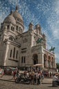 People, blue sky and Basilica of Sacre Coeur facade in Paris.