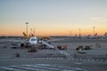 People board a commercial airplane at Milan Malpensa airport at sunset in Milan