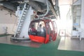 People boarded on the red colored cable car ropeway from the ground station vista dome at the tourist destination and snow ski Royalty Free Stock Photo