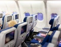 Aircraft interior with seats and blank touch screens displays. Royalty Free Stock Photo