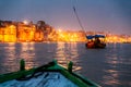 People on the boat floating on the river are going to pray at Varanasi Ganga Aarti at holy Dasaswamedh Ghat.