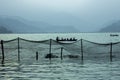 A people in a boat on the lake against the evening silhouettes of mountains. fishing net on the water Royalty Free Stock Photo