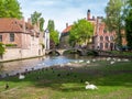 People in boat, Wijngaard bridge over canal and birds in park of Wijngaardplein in Bruges, Belgium