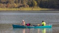 People boating on a forest lake and having fun with their dog. Hiking and traveling with a dog Royalty Free Stock Photo