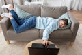 bored man with laptop lying on sofa at home Royalty Free Stock Photo