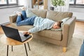 bored man with laptop lying on sofa at home Royalty Free Stock Photo