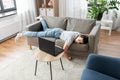 Bored woman with laptop lying on sofa at home Royalty Free Stock Photo