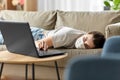 Sick bored woman with laptop lying on sofa at home Royalty Free Stock Photo