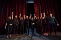 People bowing to audience. Group of actors in dark colored clothes on rehearsal in the theater