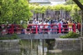 Tokyo, Japan May 3 ,2019 :people on a bridge holding red balustrade watching on a pond in wisteria festival garden in tokyo shrine