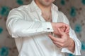 People, business, fashion and clothing concept - close up of man dressing up and fastening buttons on shirt at home. men wear a Royalty Free Stock Photo