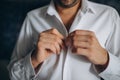 People, business, fashion and clothing concept - close up of man dressing up and fastening buttons on shirt at home Royalty Free Stock Photo