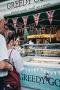 People buying ice-cream from Greedy Goat market stand in Borough Market, London, UK.