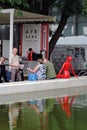 People at a cafe by the water. Red plastic woman figure.