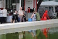 People at a cafe by the water. Red plastic woman figure.