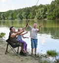 People camping and fishing, family active in nature, fish caught on bait, river and forest, summer season Royalty Free Stock Photo