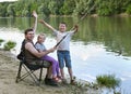 People camping and fishing, family active in nature, fish caught on bait, river and forest, summer season Royalty Free Stock Photo