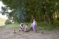 People camping in forest, family active in nature, kindle fire, summer season Royalty Free Stock Photo