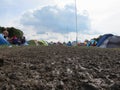 People Camping In Muddy Field At Music Festival