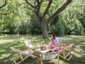 People on canvas chair in garden having afternoon tea and relaxing. Royalty Free Stock Photo