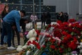 People carry flowers, candles, toys to a spontaneous memorial near the Crocus City Hall building