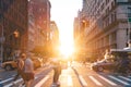 People, cars, bicycles and buses traveling through a busy intersection on 5th Avenue and 23rd Street in New York City with