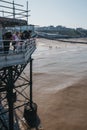 People catching crabs with buckets lowered from Cromer pier, Norfolk, UK