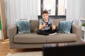 Bored boy with remote control watching tv at home Royalty Free Stock Photo