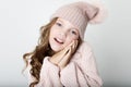 People, childhood and fashion concept: little girl child wearing pink winter hat and sweater over pink background Royalty Free Stock Photo