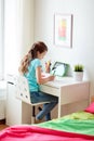 Girl with tablet pc writing to notebook at home Royalty Free Stock Photo