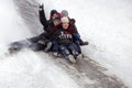 People Children ride on the winter snow sledding from hills. Winter playing, fun, snow Royalty Free Stock Photo