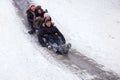 People Children ride on the winter snow sledding from hills. Winter playing, fun, snow Royalty Free Stock Photo