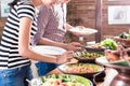 People choosing food at Indonesian buffet in restaurant