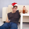 People in christmas hat sits on a floor with beer Royalty Free Stock Photo