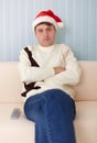 People in a Christmas hat sits on a sofa Royalty Free Stock Photo