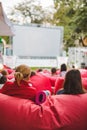 people at city public park watching movie at open air cinema