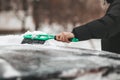 A people cleans the car from icing with a brush. Snow storm